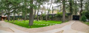 a garden with trees and a building in the background at casita antiguo lavadero in Collado-Villalba