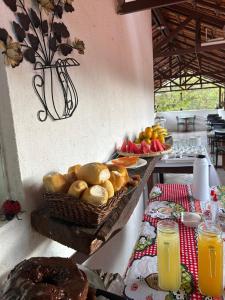 a table with bread and a basket of fruit and juice at Pousada Núcleo da Serra in Serra do Cipo +47 photos