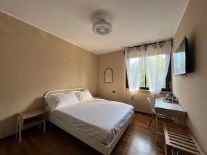 a bedroom with a bed and a desk and a window at La Rosa del Golfo dei Poeti in La Spezia