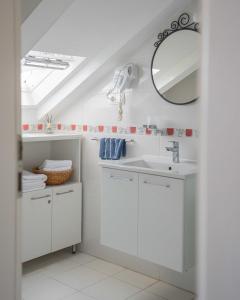 a white bathroom with a sink and a mirror at Apartment The Charm in Split +20 photos
