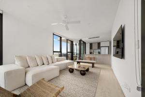 a living room with a white couch and a table at Seren - Luxury Ocean Views With Pool And Gym in Gold Coast