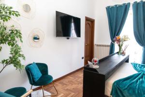 a living room with a tv and blue chairs at Suite Room Con Vasca Idromassaggio in Aversa
