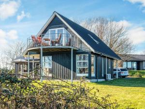 a house with a balcony on the side of it at Panoramic Fjord Retreat with Spa Bath in Øster Assels
