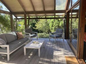 a screened in porch with a couch and chairs at Treetop Studio in Wellington