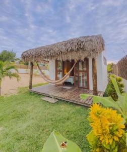 eine kleine Hütte mit Hängematte im Gras in der Unterkunft Moitas Chalés in Curralinho + 12 Fotos