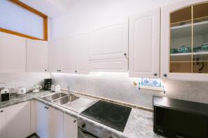 a kitchen with white cabinets and a sink at Infinity Experience Casa Vacanza Incantevole con Terrazzo in Scala +67 photos