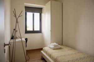 a small bedroom with a bed and a window at 12 Casa d'Avó in Albergaria-a-Velha +33 photos
