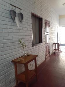 a room with a table and a white brick wall at Yvoty miní in Puerto Iguazú +2 photos