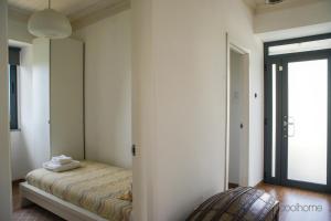 a bedroom with a bed with a mirror on the wall at 12 Casa d'Avó in Albergaria-a-Velha