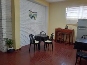 a dining room with a table and chairs and a kitchen at Yvoty miní in Puerto Iguazú