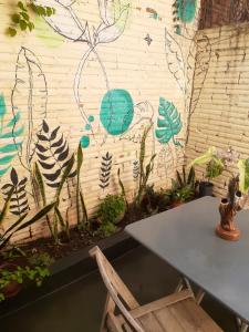 a table and a chair in front of a wall at Yvoty miní in Puerto Iguazú