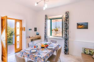 a dining room with a table and a window at Infinity Experience Casa Vacanza Incantevole con Terrazzo in Scala