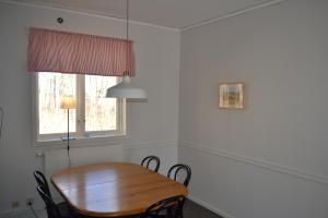 - une table et des chaises en bois dans une chambre avec fenêtre dans l'établissement Ljungsbro Vandrarhem, à Ljungsbro