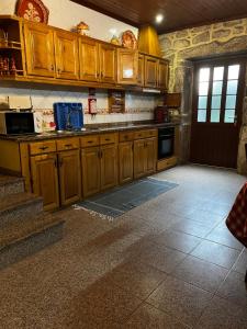 a large kitchen with wooden cabinets and a door at Casa da Venda in Covide +18 photos