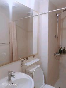 une salle de bain avec toilettes, lavabo et miroir dans l'établissement Anuva Lovely Homes, à Manille