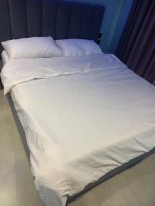 a large bed with white sheets and pillows at Green Coast Escape in Palasë