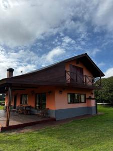 a house with a balcony on top of it at Casa de campo - Paraiso Natural en Laguna de los Padres in Sierra de los Padres