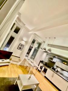 a living room with white furniture and windows at Cozy Studio Apartment in Leeds