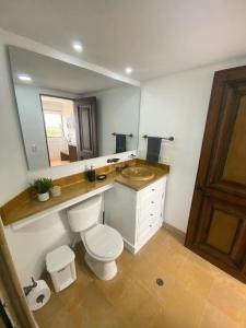 um banheiro com vaso sanitário, pia e espelho em Cabrero Beach 1008 em Cartagena de Indias