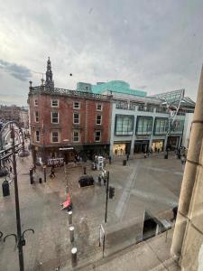 a city square with a large brick building with a clock tower at Cozy Studio Apartment in Leeds