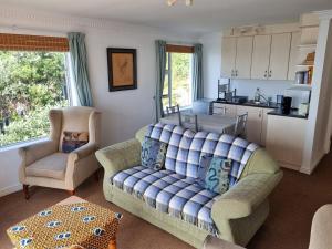 a living room with a couch and two chairs and a kitchen at Bargain for 8 persons in Fish Hoek