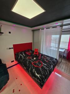 a bedroom with a bed with red roses on it at C12 Deluxe in Cap d'Agde