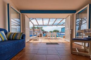 a living room with a blue couch and a patio at Appartamento a pochi passi dal mare con servizio spiaggia incluso in Terracina