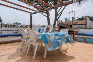 a table with white chairs and a blue table cloth at Appartamento a pochi passi dal mare con servizio spiaggia incluso in Terracina