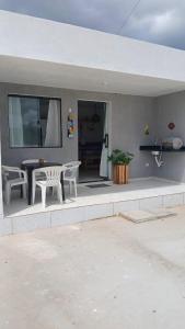 a patio with a table and chairs in a house at Vila Negreiros Serra Negra Casa 3 in Bezerros