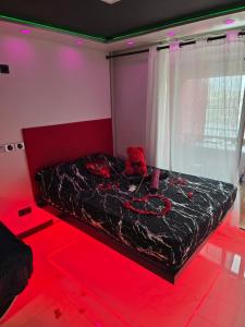 a bedroom with a bed in a room with red lights at C12 Deluxe in Cap d'Agde