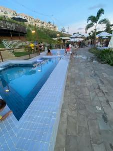 a pool at a resort with people swimming at Descanso e lazer in Parnamirim