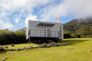 a house on a field with rocks in front of it at Mini casa premium Dominó in Tafí del Valle