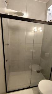 a glass shower in a bathroom with a toilet at Studio 61- No Coração de Curvelo in Curvelo +17 photos