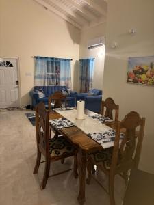 a dining table and chairs in a living room at Jepel's Escape in Florence Hall