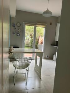 een keuken met een witte tafel en een stoel bij Refugio Sur in Puerto Madryn