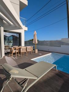 a patio with a table and chairs next to a swimming pool at Caparica Sun & Serenity in Charneca