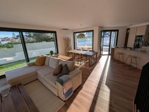 a large living room with a couch and a kitchen at Caparica Sun & Serenity in Charneca