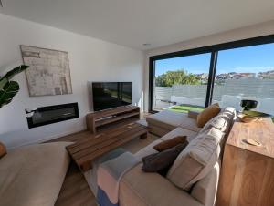 a living room with two couches and a tv at Caparica Sun & Serenity in Charneca