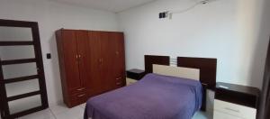 Schlafzimmer mit einem lila Bett und einem Holzschrank in der Unterkunft Casa moderna estilo minimalista muy luminosa in San Javier