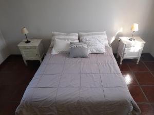 Un dormitorio con una cama grande con dos mesitas de noche. en La casita de Todd, en Todd