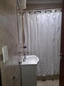 Un baño con lavabo y cortina de ducha. en La casita de Todd, en Todd