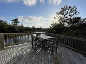 a wooden deck with a table and benches on a bridge at ISLAND DREAMING RETREAT cottage in Frisco