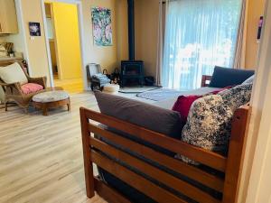 a living room with a couch in front of a window at The Groves at Redway Beach - Studio in Redway