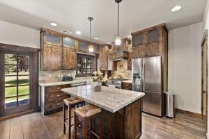 une cuisine avec des placards en bois et un grand îlot avec des tabourets de bar dans l'établissement CYH1012 - Hidden Cedar home, à South Lake Tahoe