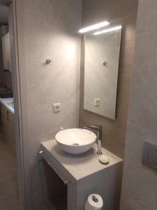 un baño con lavabo y espejo en Theasis Deluxe, en Lefkada