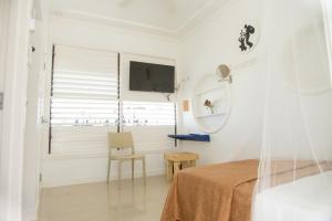 Camera bianca con letto e specchio di Begona Cliff Hotel a Negril