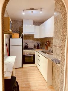 Una cocina con gabinetes blancos y un refrigerador blanco. en Casa Hermosa, en Fortuna