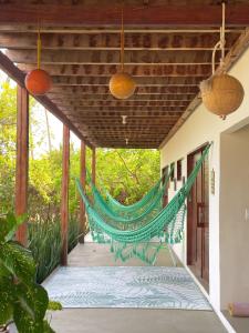 a hammock hanging from the porch of a house at Casa Ingapura Suite Tainha - Povoado Bar da Hora 15 min de canoa para Atins - Estilo B&B - Café da Manhã Simples - Conforto in Atins