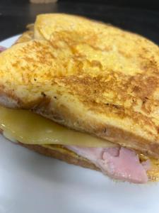 un sándwich con queso y jamón en un plato blanco en Oasis Exchange Hotel, en Torrens Creek