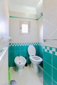 a green and white bathroom with a toilet and a sink at L'Orologio in Tivoli +26 photos